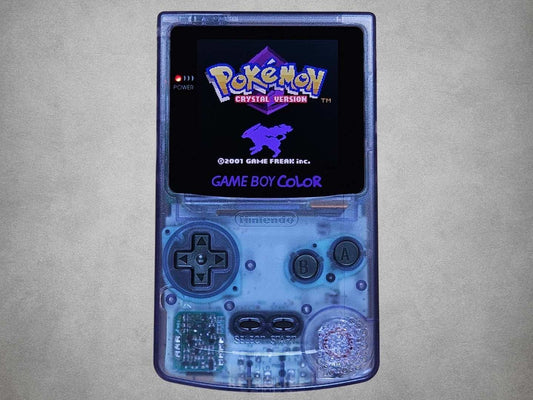 Transparent Atomic Purple Game Boy Color with 'Pokémon Crystal Version' on screen