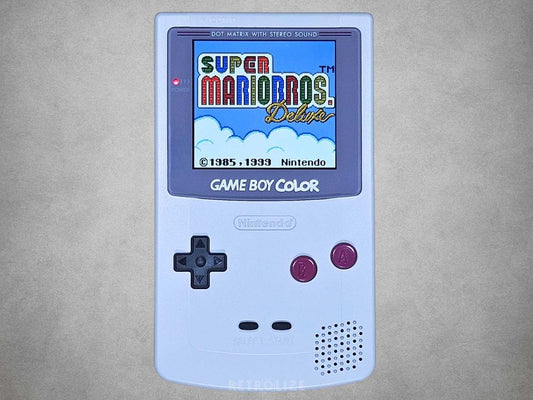 Nintendo Game Boy Color DMG Edition with grey shell, burgundy buttons and IPS screen displaying Super Mario Bros. Deluxe