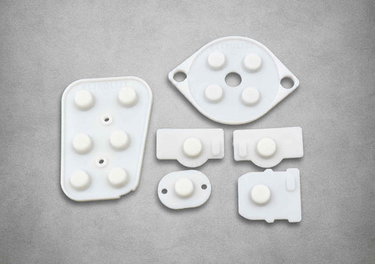 White silicone replacement button membranes for a Nintendo 64 NUS-005 controller, showing the moulded button domes