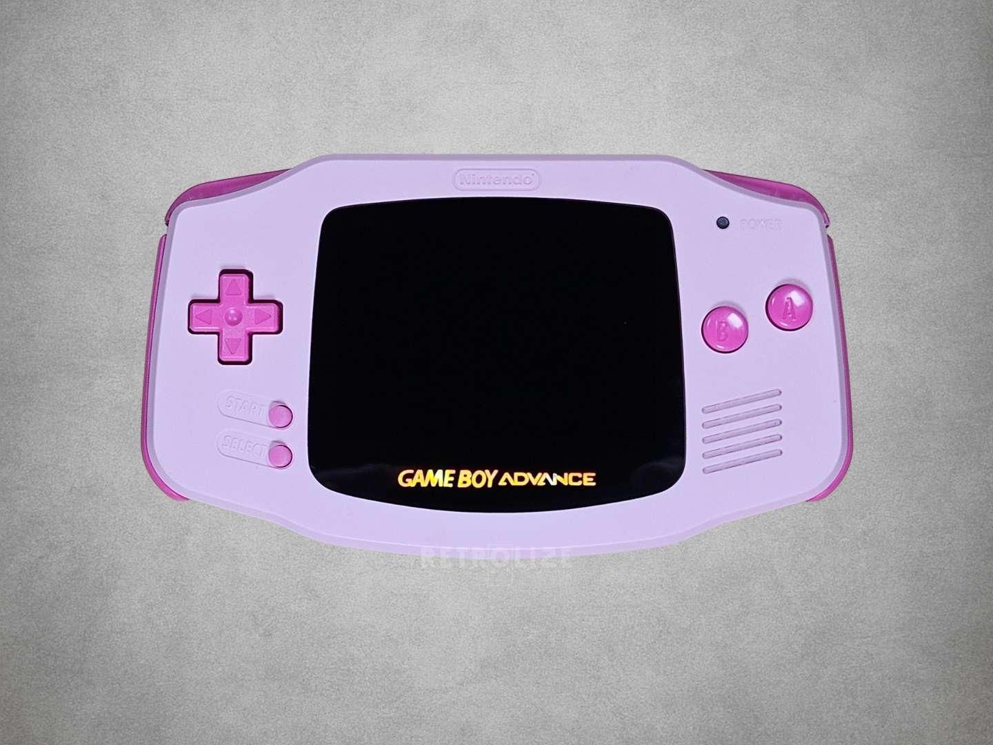 Pink Game Boy Advance with Hot Pink buttons on a grey background screen off