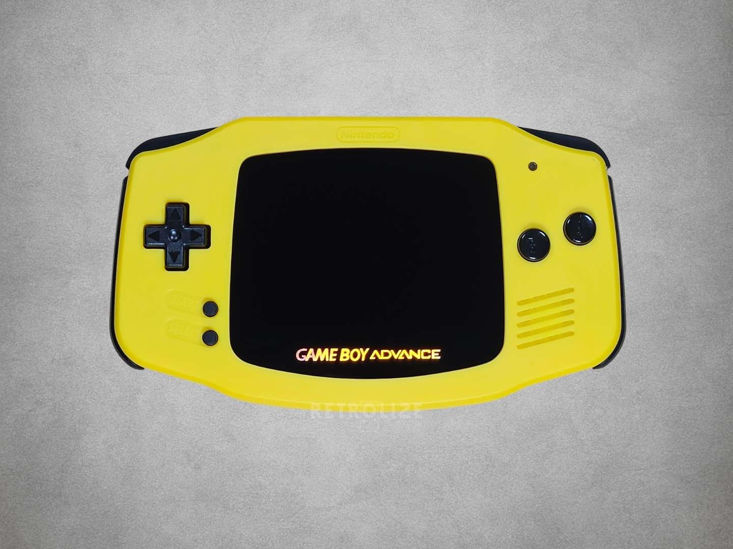 Yellow Game Boy Advance console on a grey background