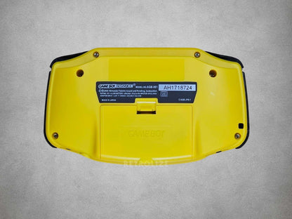 Yellow Game Boy Advance with a label on a grey background