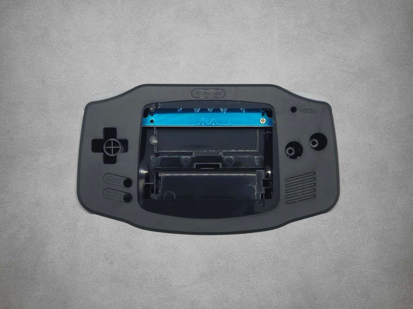 Black Game Boy Advance shell on grey background