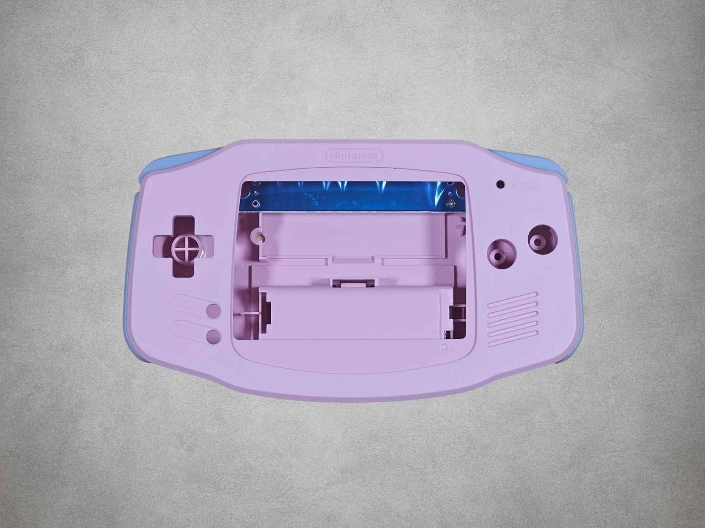Pink Game Boy Advance shell on grey background