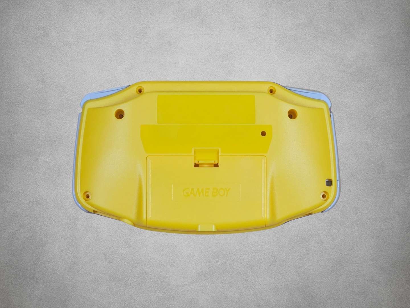 Yellow Game Boy Advance shell on grey background back