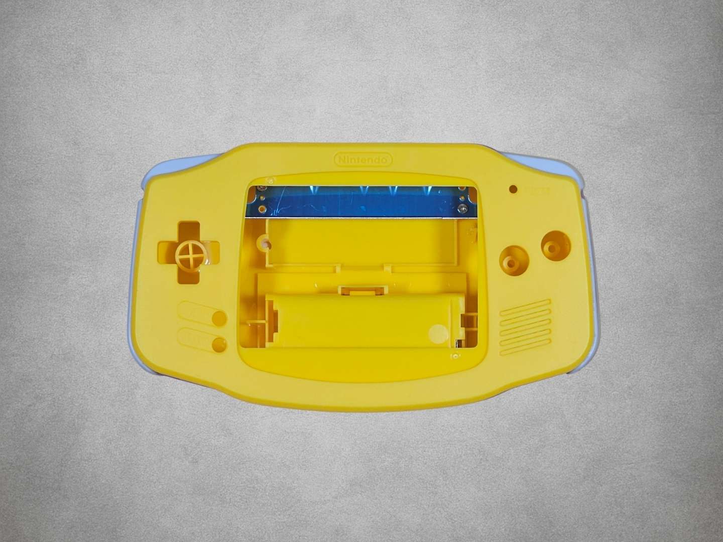 Yellow Game Boy Advance shell on grey background