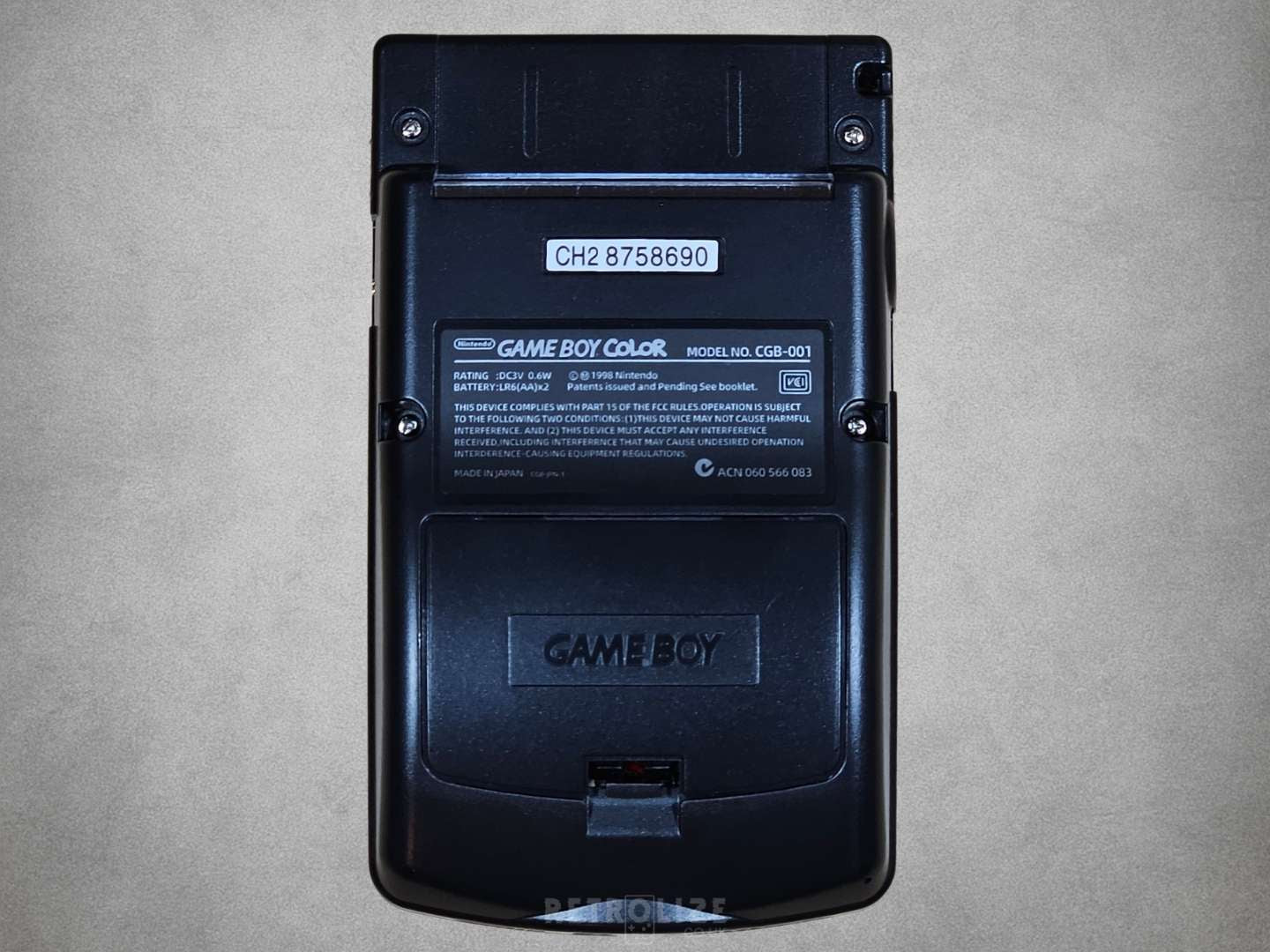 Black Nintendo Game Boy back view on a grey background

