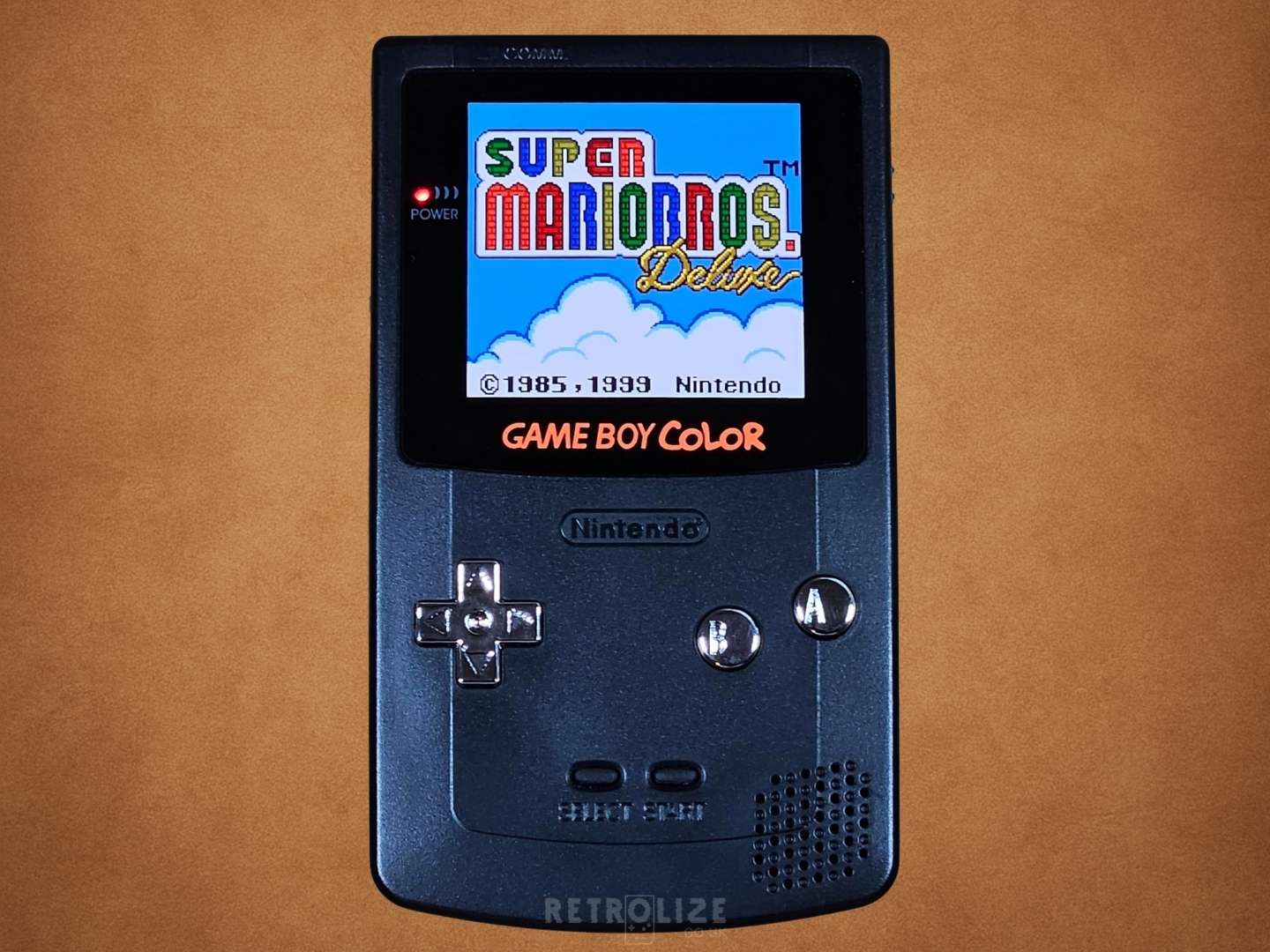 Black Game Boy Color OLED with Metallic Silver Buttons With Super Mario Bros on the screen