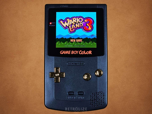 Black Game Boy Color OLED with Metallic Gold Buttons with Wario Land 3 on the Screen