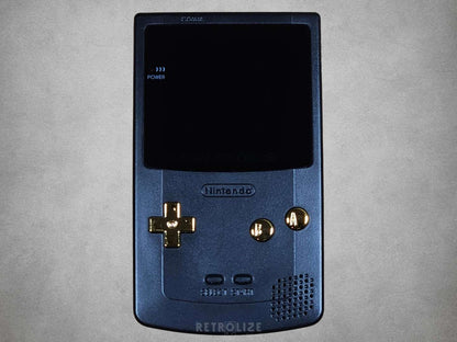 Black Nintendo Game Boy with gold buttons on a grey background

