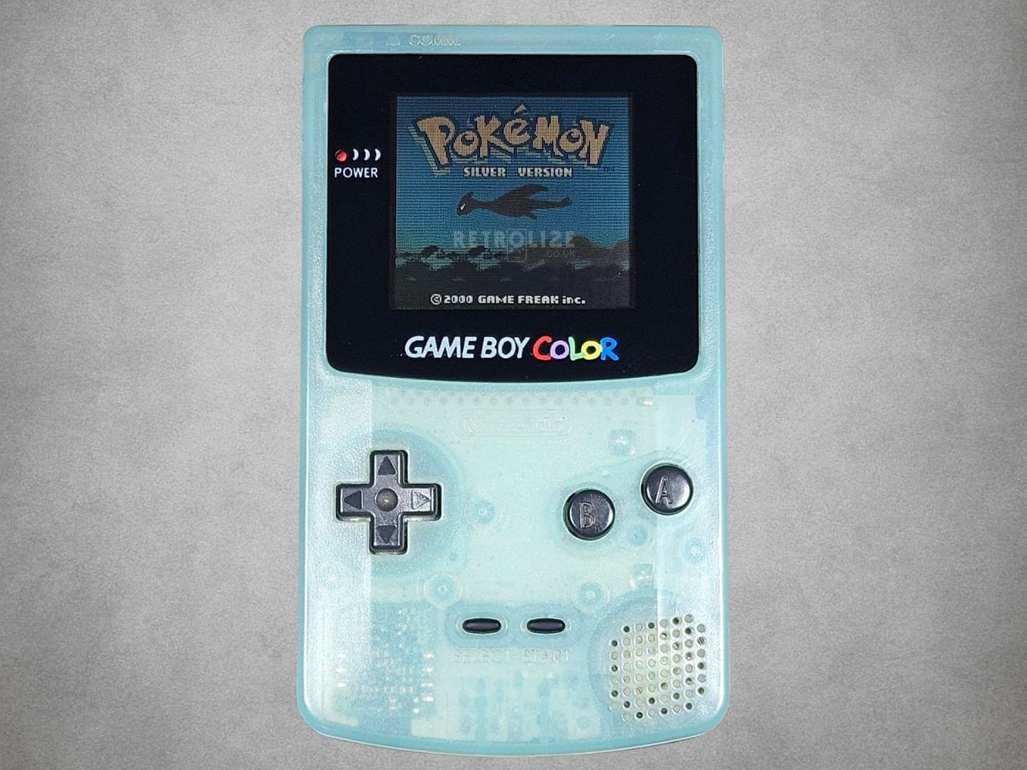 Japan Exclusive Ice Blue Game Boy Color with a screen displaying 'Pokémon' on a gray background