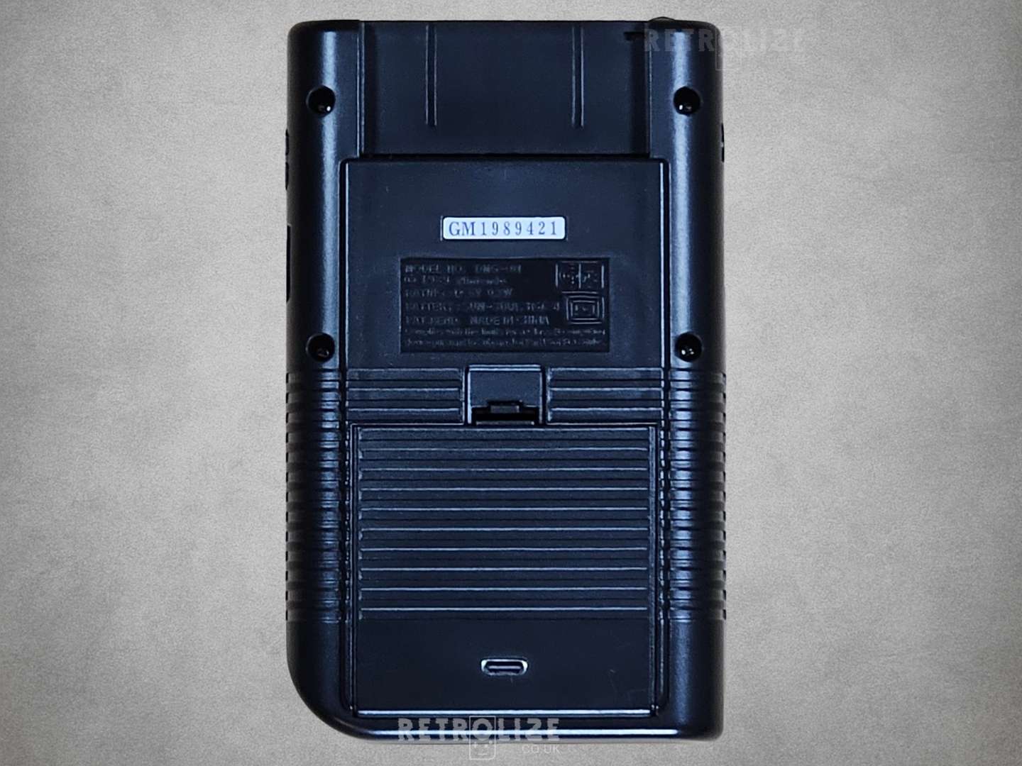 Black Game Boy DMG-01 rear view on grey background