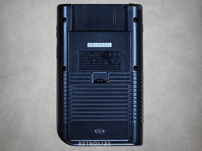 Black Game Boy DMG-01 rear view on grey background