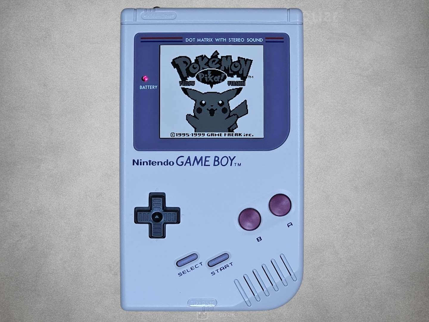 Grey Game Boy DMG-01 with Pokemon Yellow on Screen on grey background