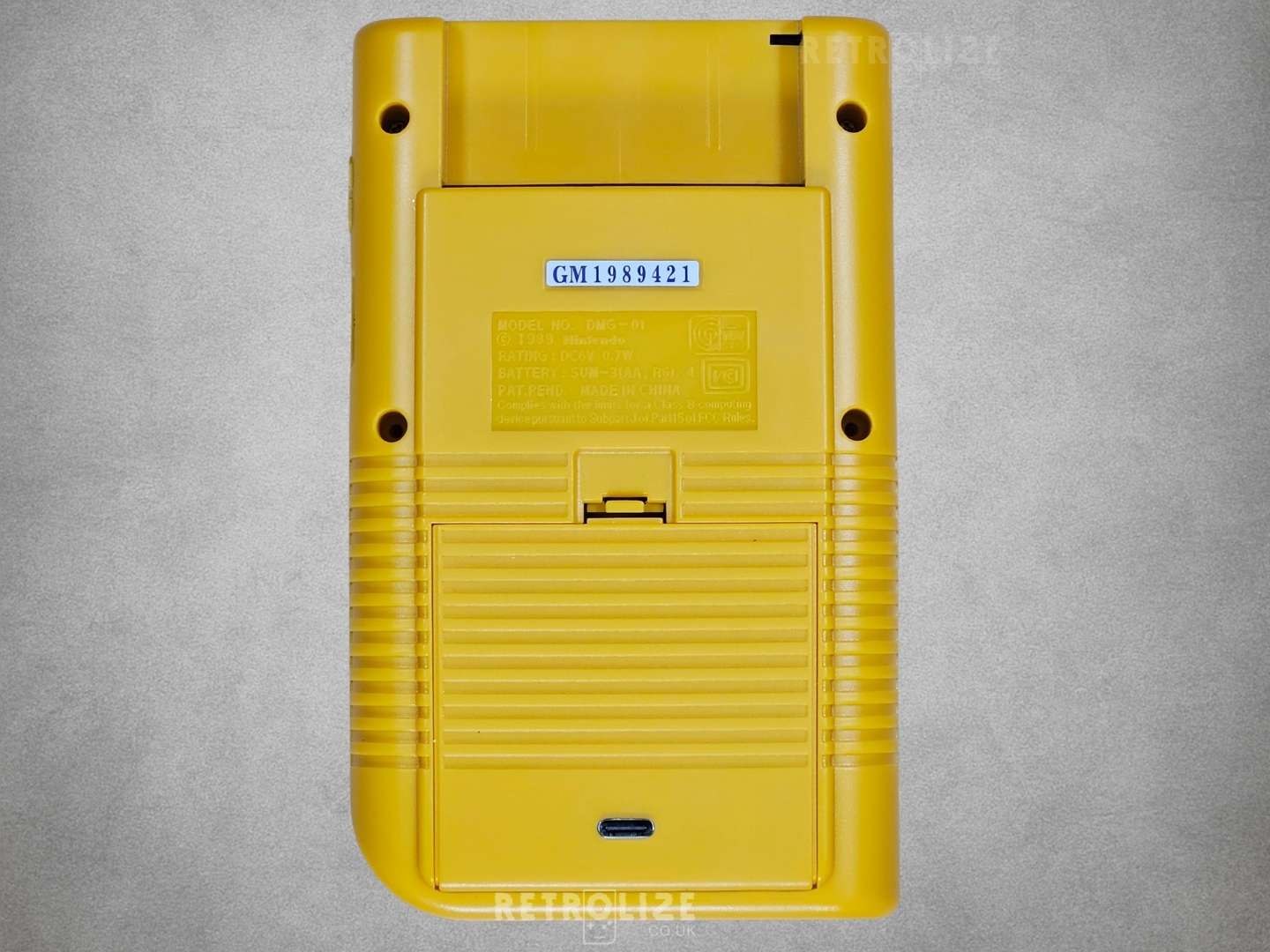 Yellow Game Boy DMG-01 rear view on grey background