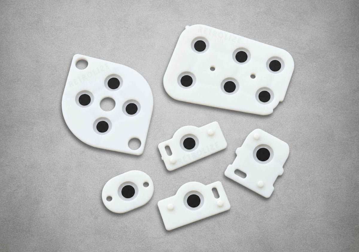 White silicone replacement button membranes for a Nintendo 64 NUS-005 controller, showing conductive black pads