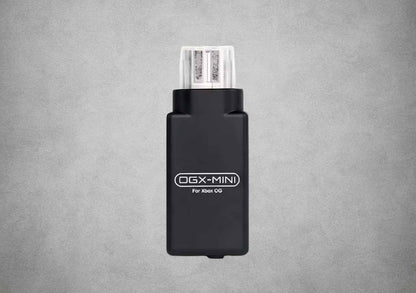 Front view of the black OGX Mini original Xbox Bluetooth controller adapter on a grey background