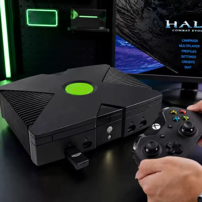 OGX Mini connected to an original Xbox console while a player uses a modern Xbox wireless controller